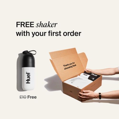 someone holding a Huel box containing a white powder bag, and a black and white shaker, on a neutral background