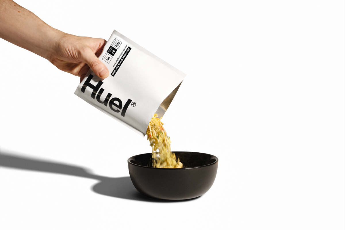 Image of someone pouring a sachet of Huel Hot & Savoury into a bowl