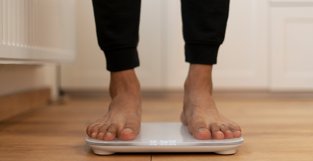 close up of mans barefeet stood on digital scales