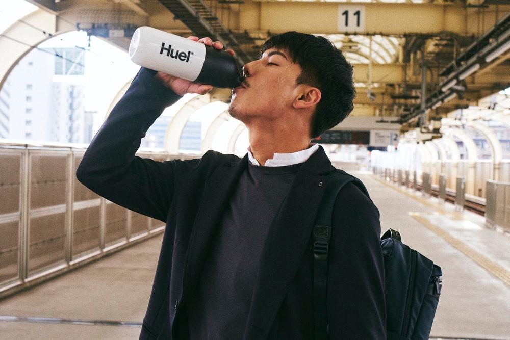 Japanese man drinking from a Huel Shaker