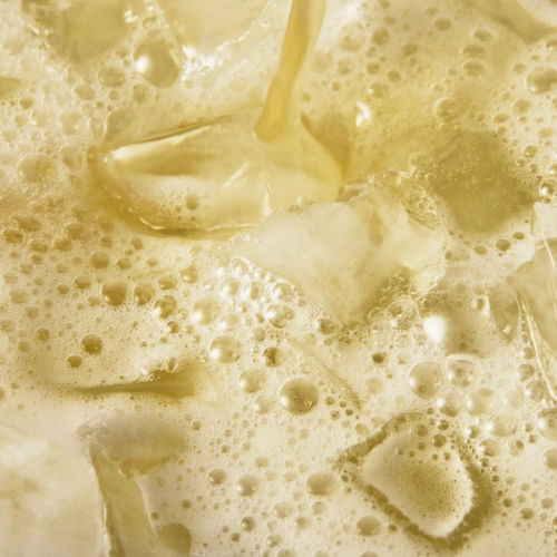 A close up of a glass of Daily Greens Ready-to-drink in a glass with ice