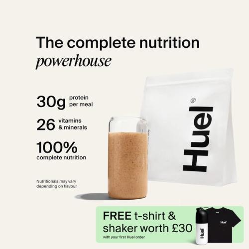 A bag of Huel powder next to a glass containing a Huel drink on a neutral background