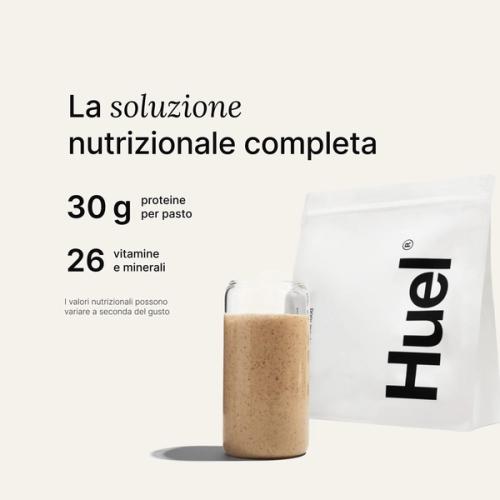 Una confezione di Huel Powder accanto a un bicchiere contenente una bevanda Huel su uno sfondo neutro