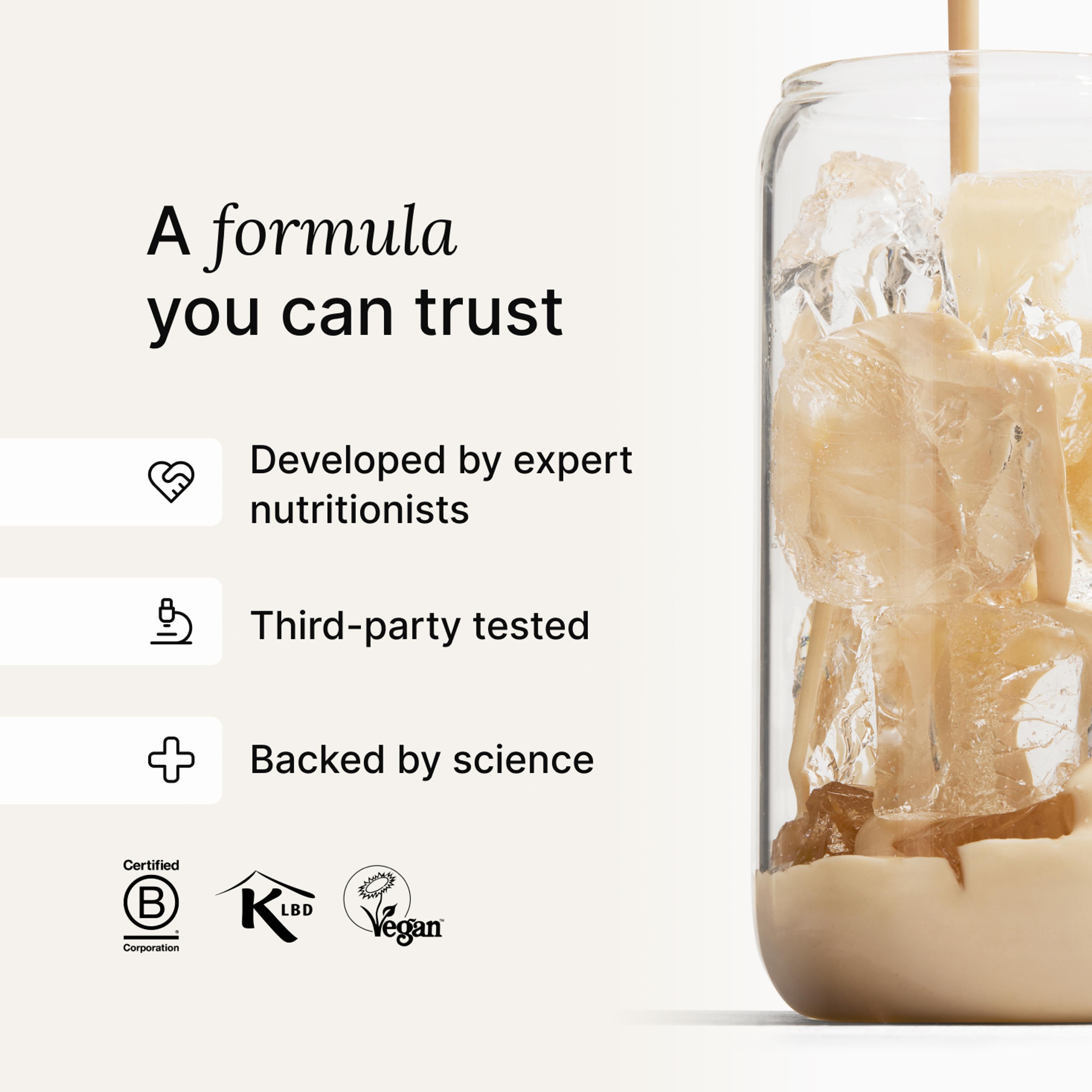 Huel vanilla shake being poured into a glass with ice, against a neutral background
