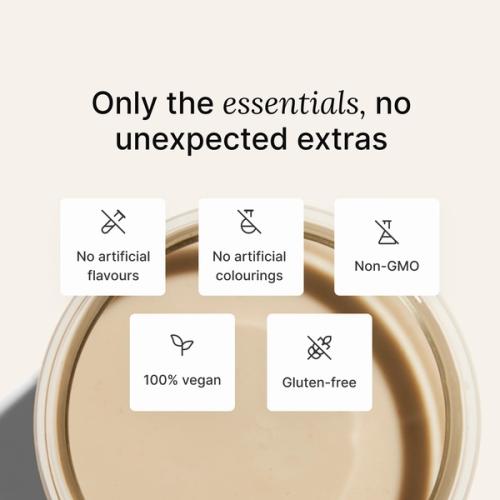 A glass of Huel complete protein shake on a neutral colour background