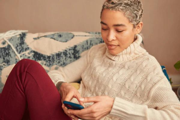 Woman on her phone sat on the sofa
