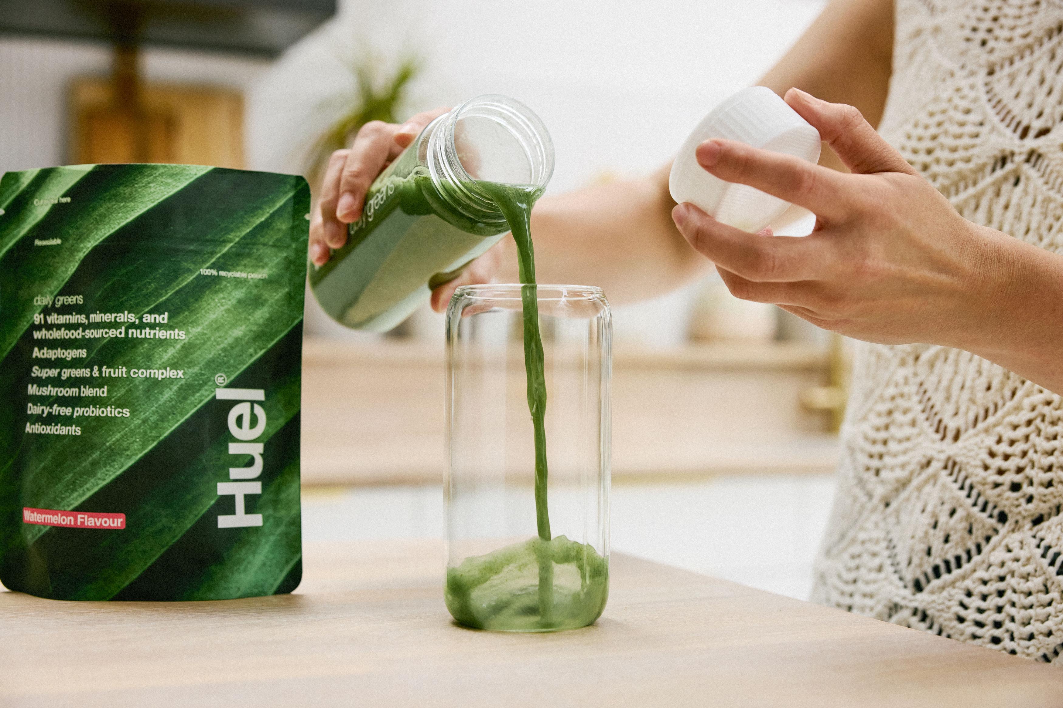 Woman pouring Daily Greens into a glass