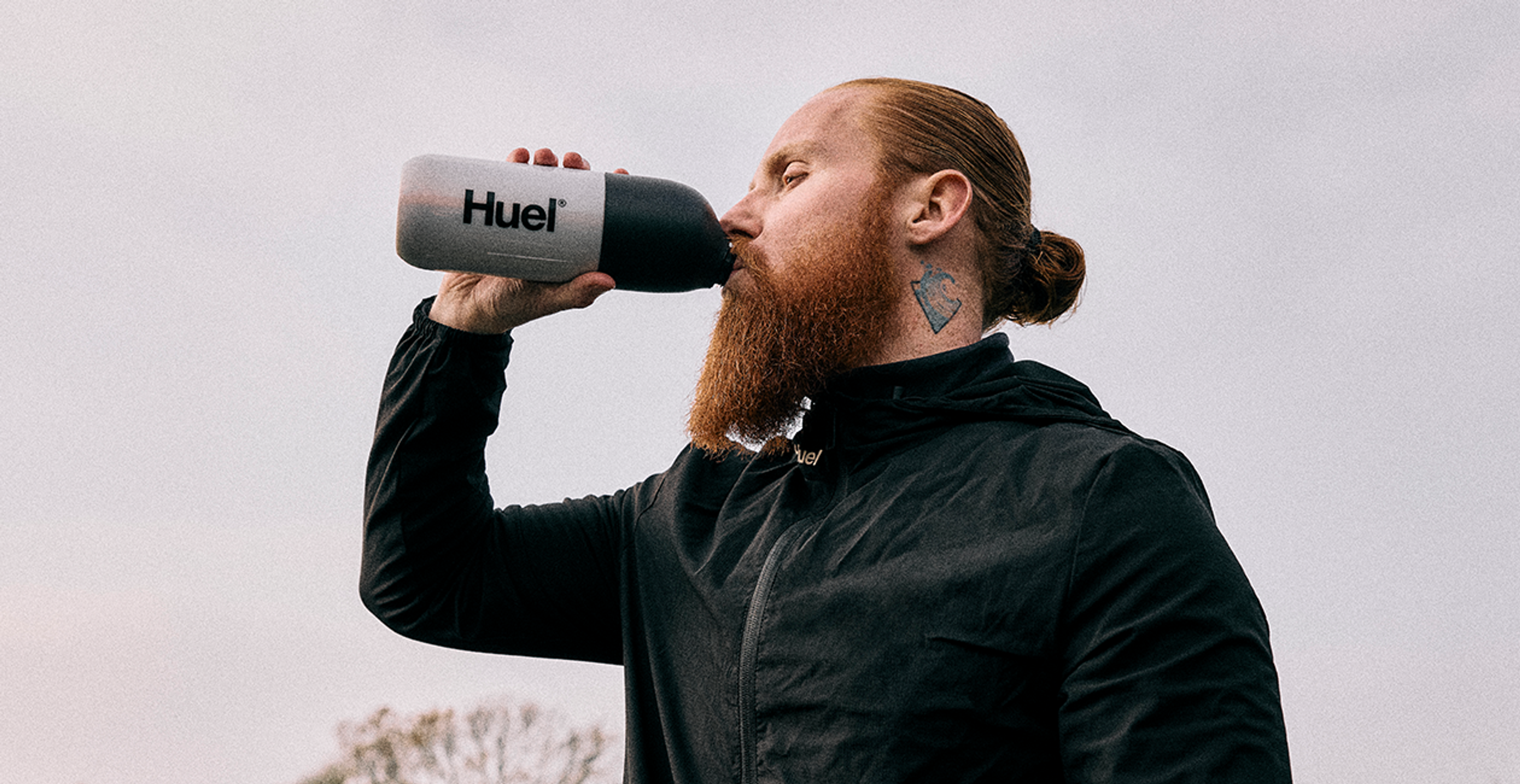 Russ Cook drinking from a Huel shaker outside