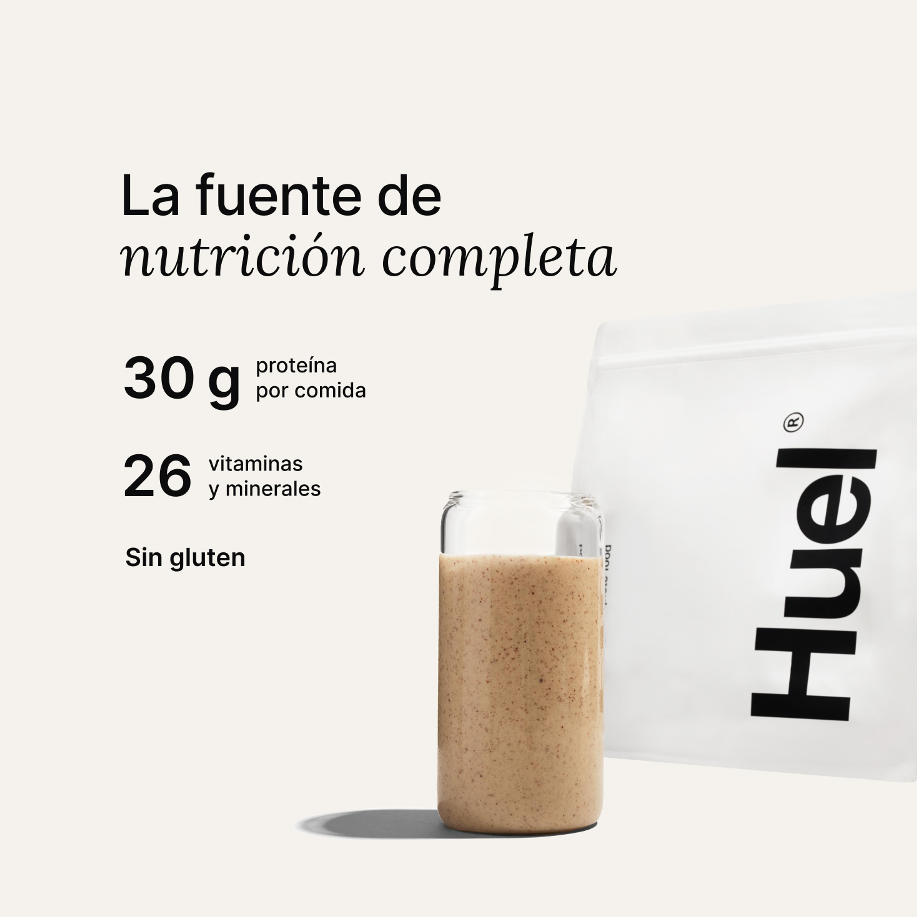 Una bolsa de Huel Powder junto a un vaso que contiene una bebida de Huel sobre un fondo neutro