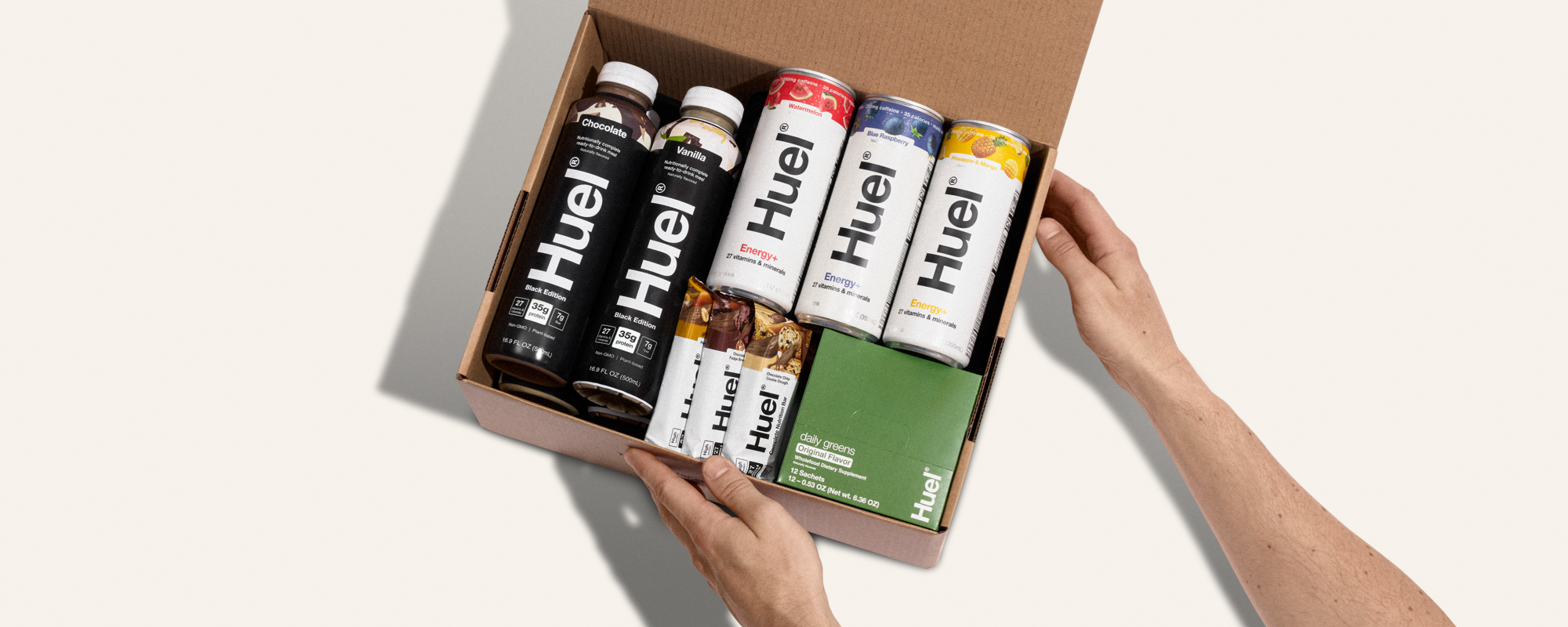 Unboxing a Huel delivery - the brown cardboard box contains multiple Huel powders, protein drinks, and protein snacks