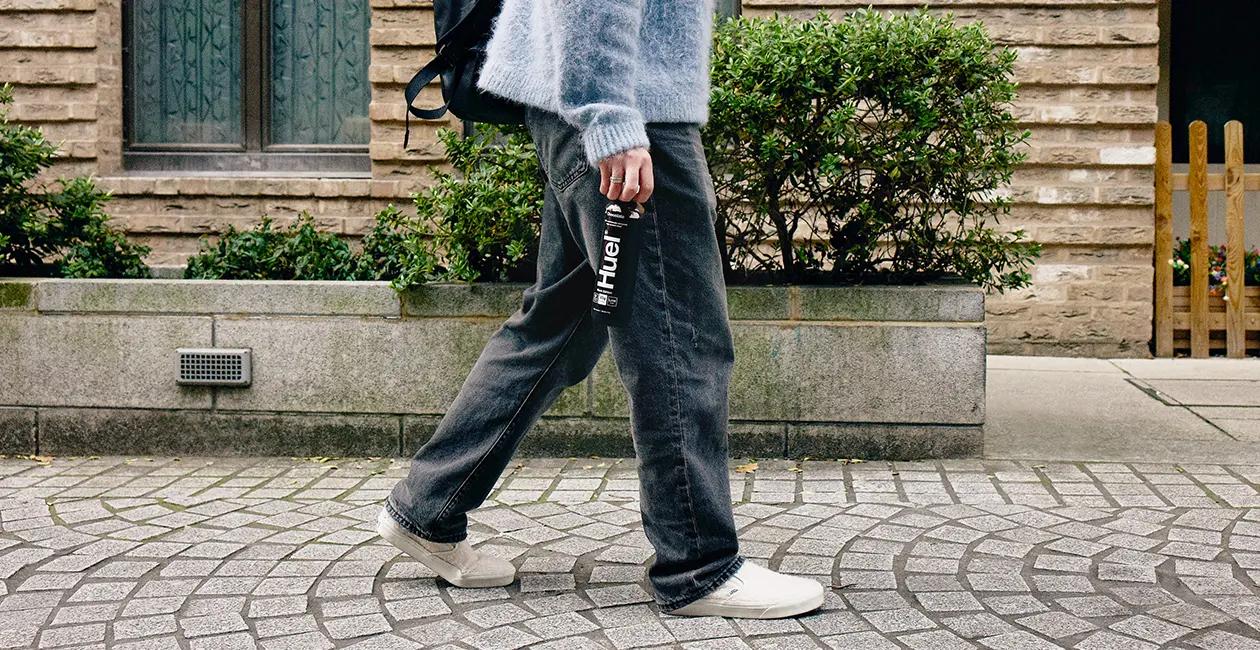 person walking down street holding a Huel Black Edition Ready-to-drink