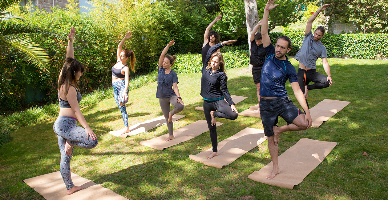 A group of people outside doing a yoga class