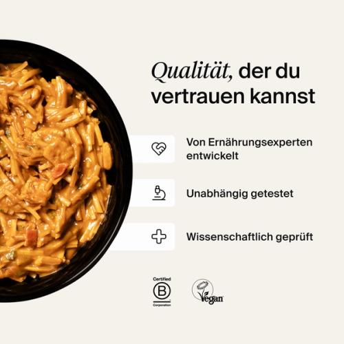 A bowl of Huel Hot & Savoury with fresh chilli and coriander on a neutral background