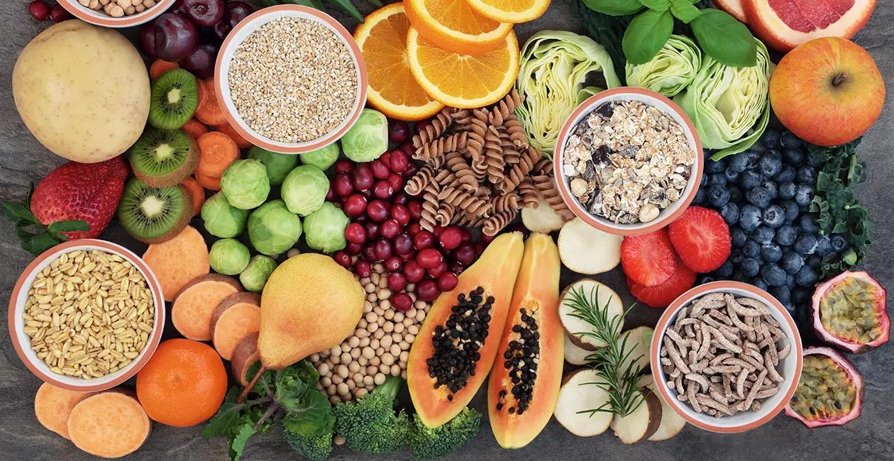 a collection of colourful and vibrant whole foods including grains pastas fruit and veg