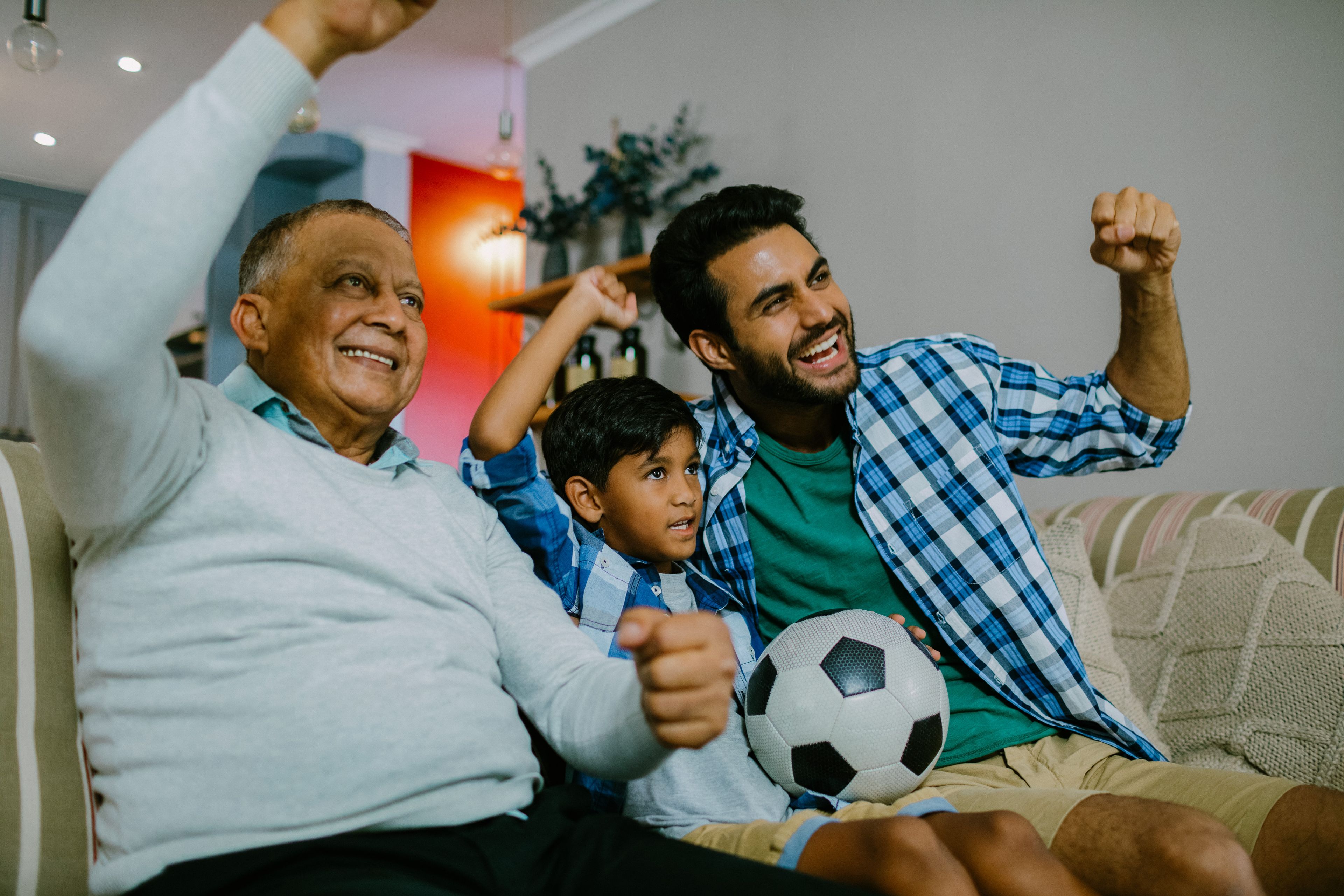 Multi-generational family of the males watching a soccer game