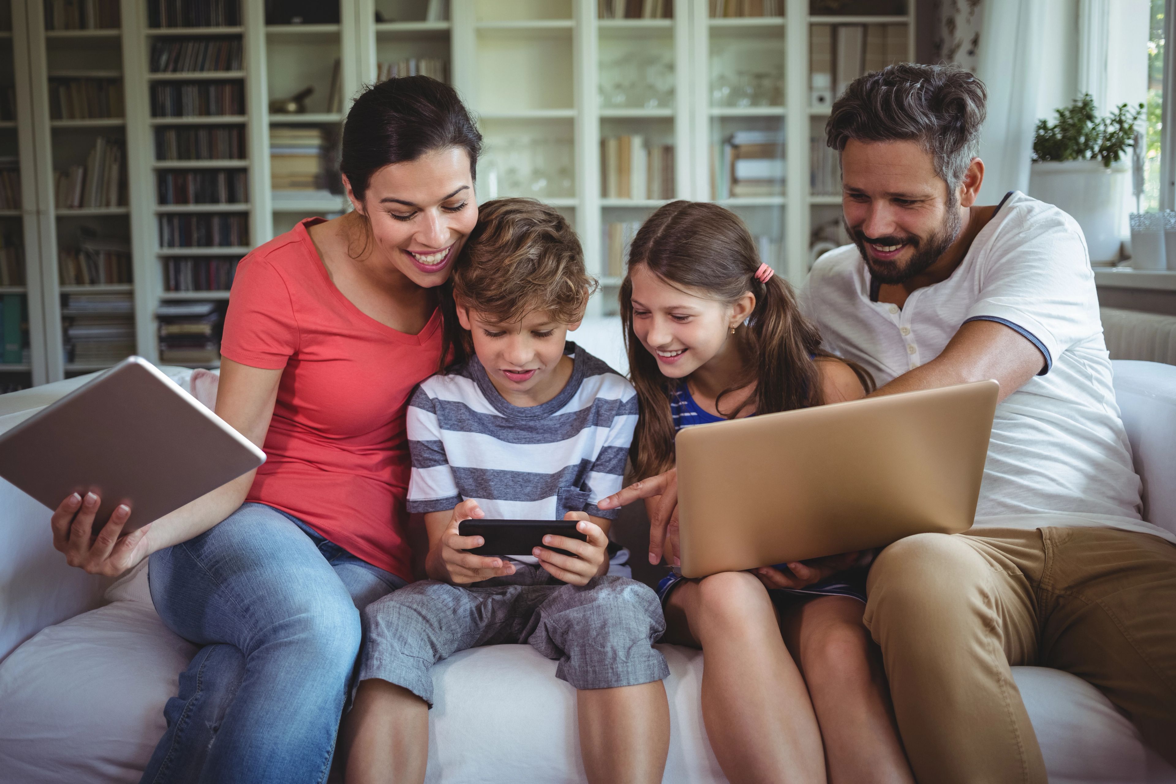 Family smiling looking at videogame