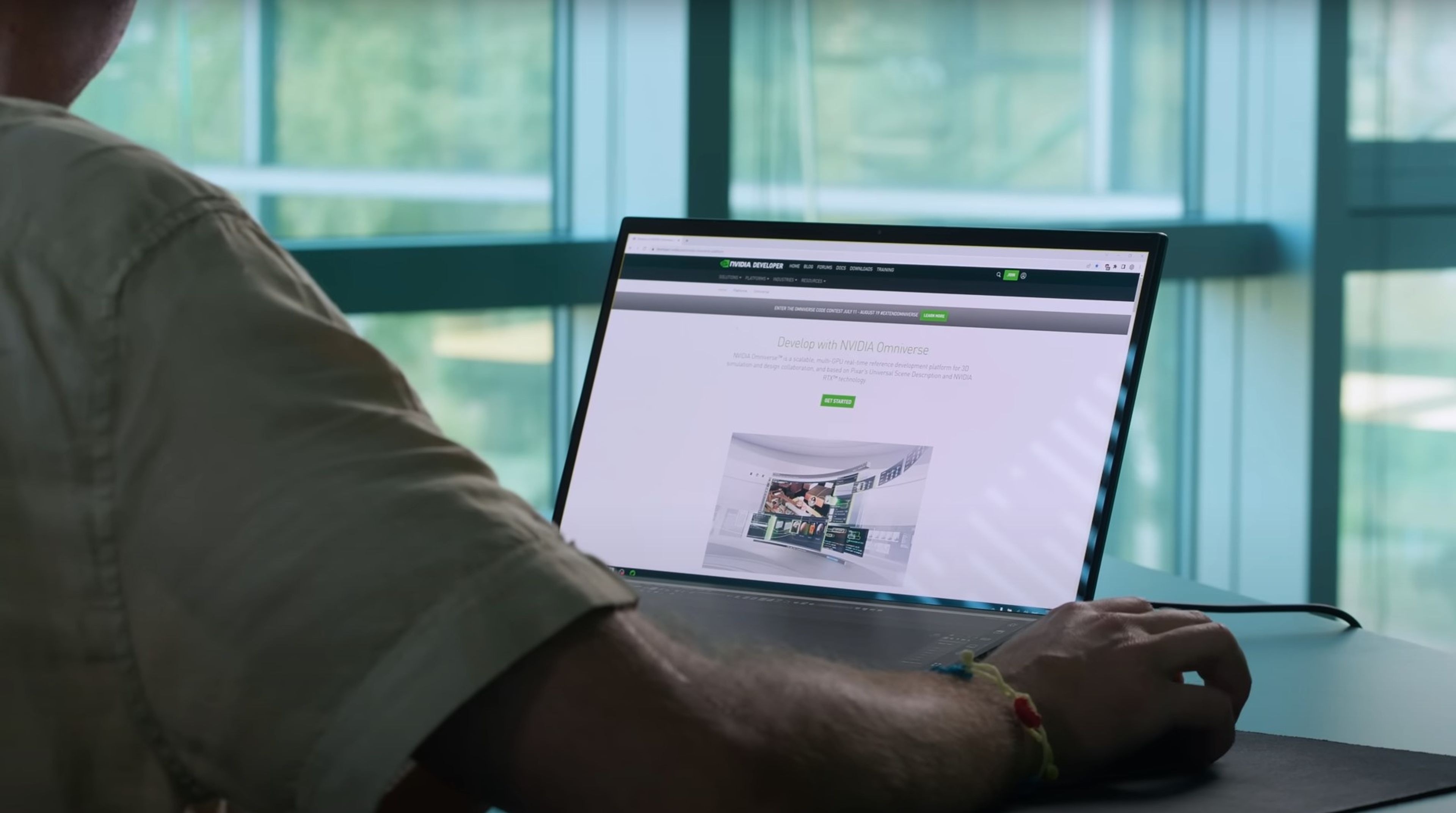 a man is sitting at a desk using a laptop computer .