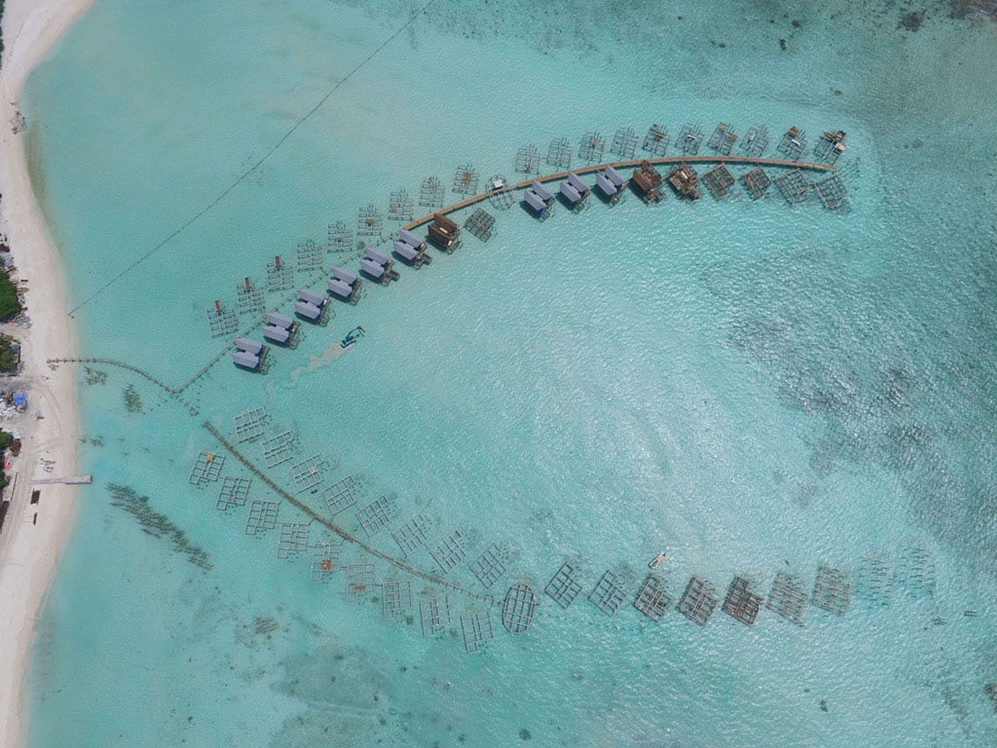 an aerial view of a row of bungalows in the middle of the ocean .