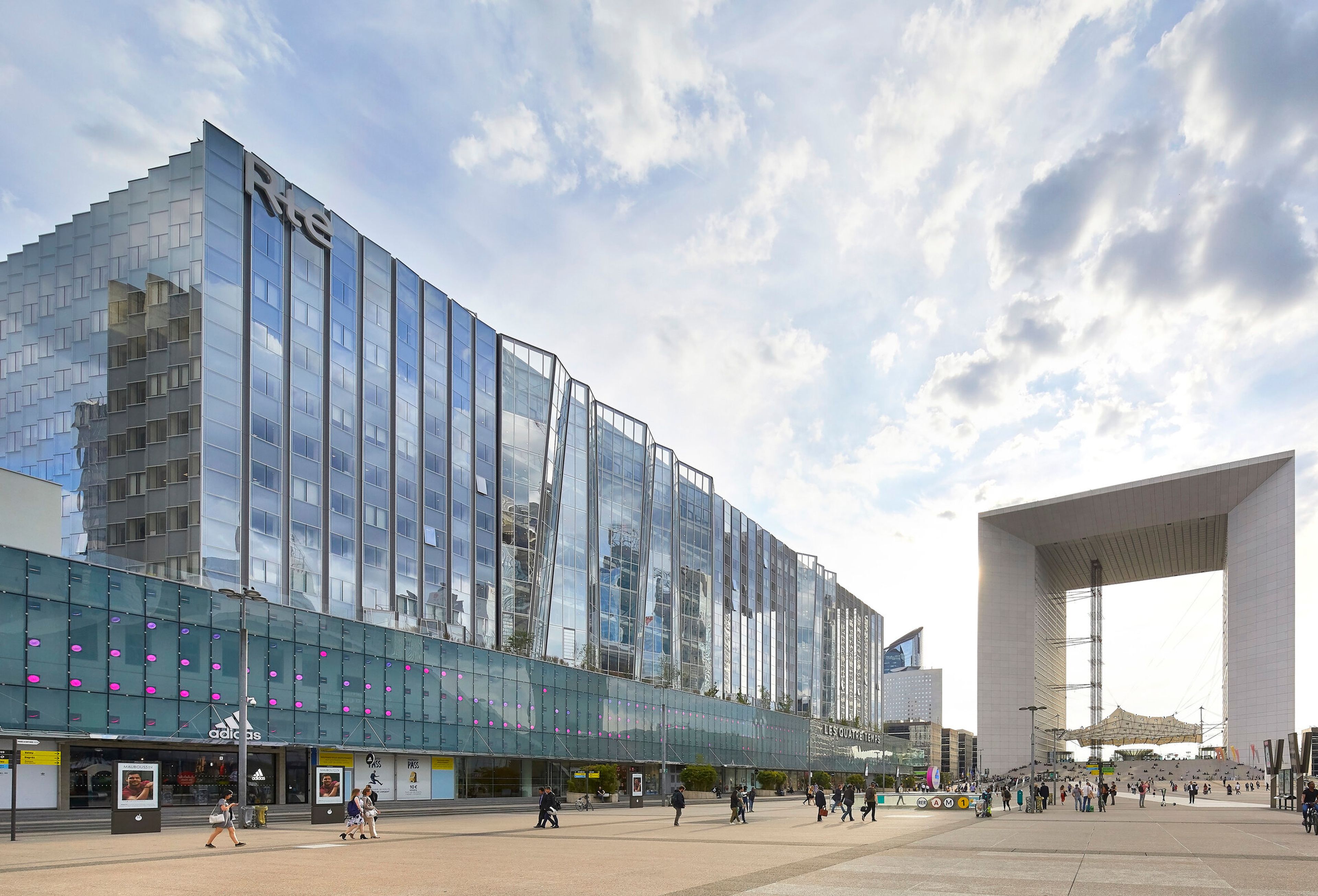 a large building with a lot of windows and a large arch in the background .