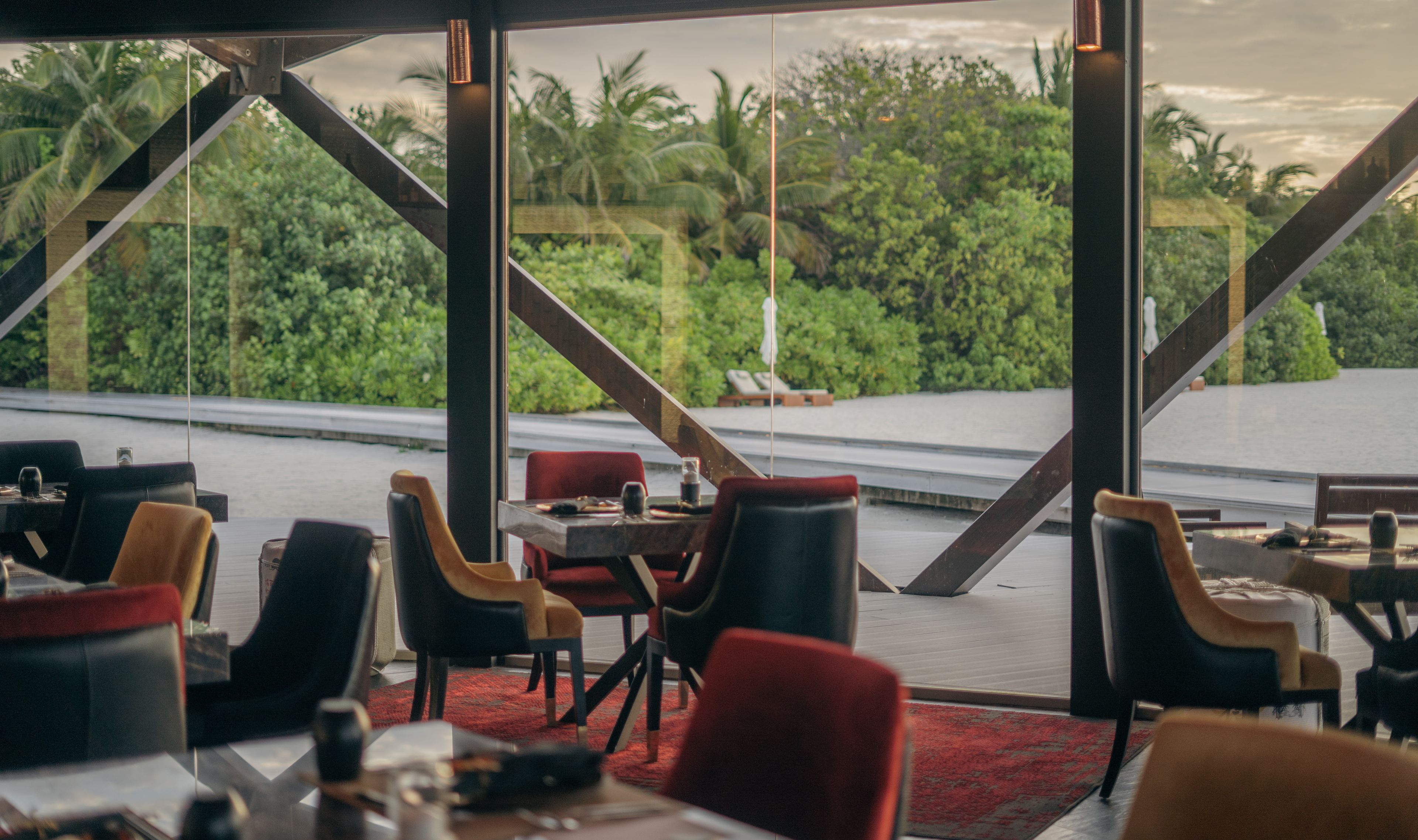 a restaurant with tables and chairs and a view of the jungle .