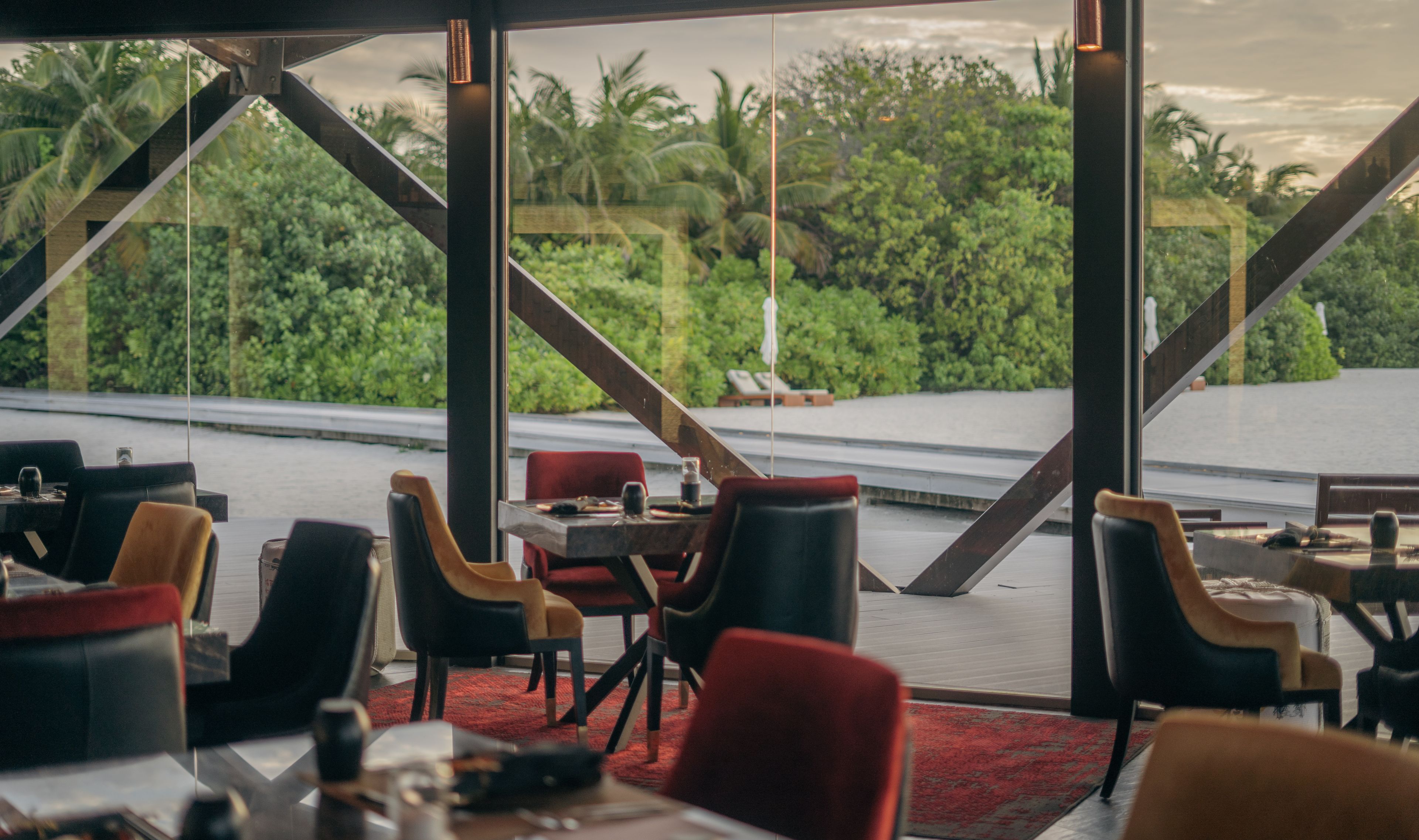 a restaurant with tables and chairs and a view of the jungle .