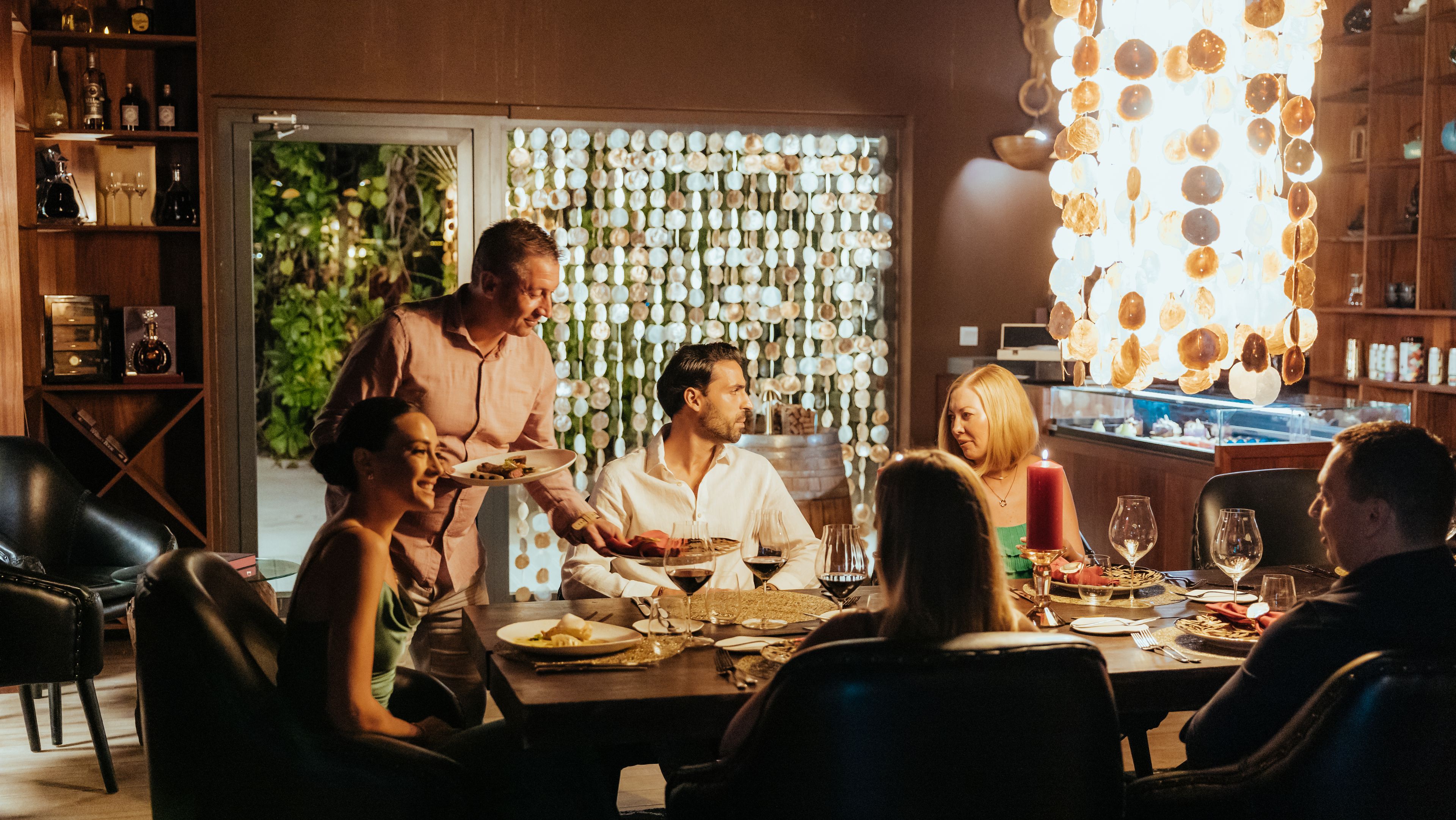 a group of people are sitting at a table in a restaurant .