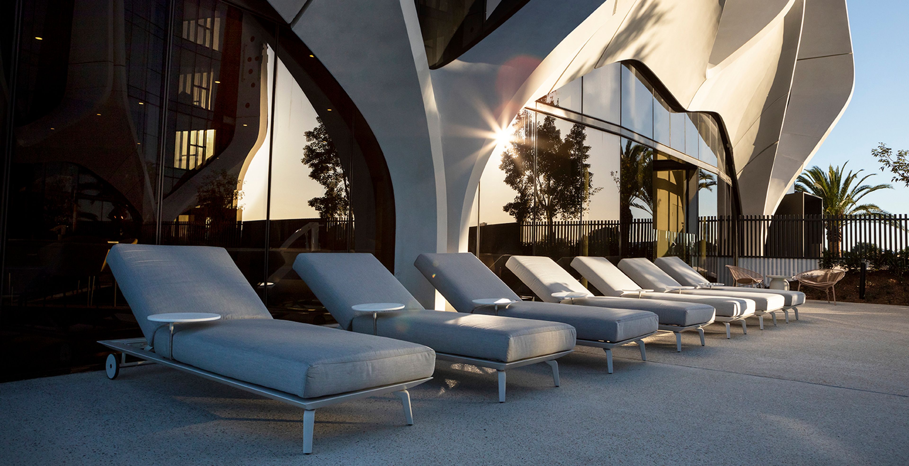 a row of lounge chairs are lined up in front of a building .