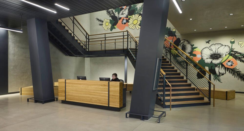 a woman in a black dress is looking out of a window .