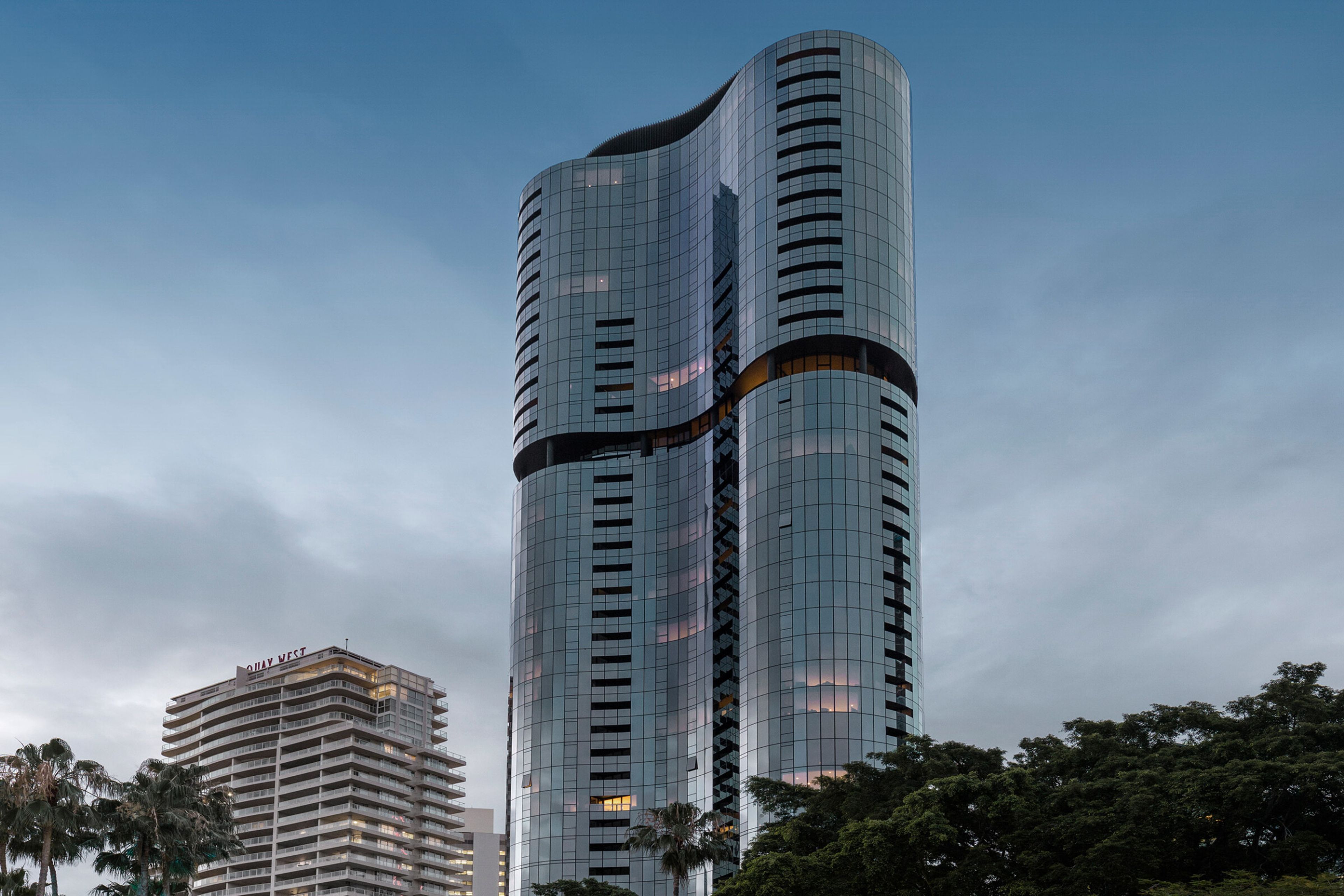 a tall building with a lot of windows is surrounded by trees .