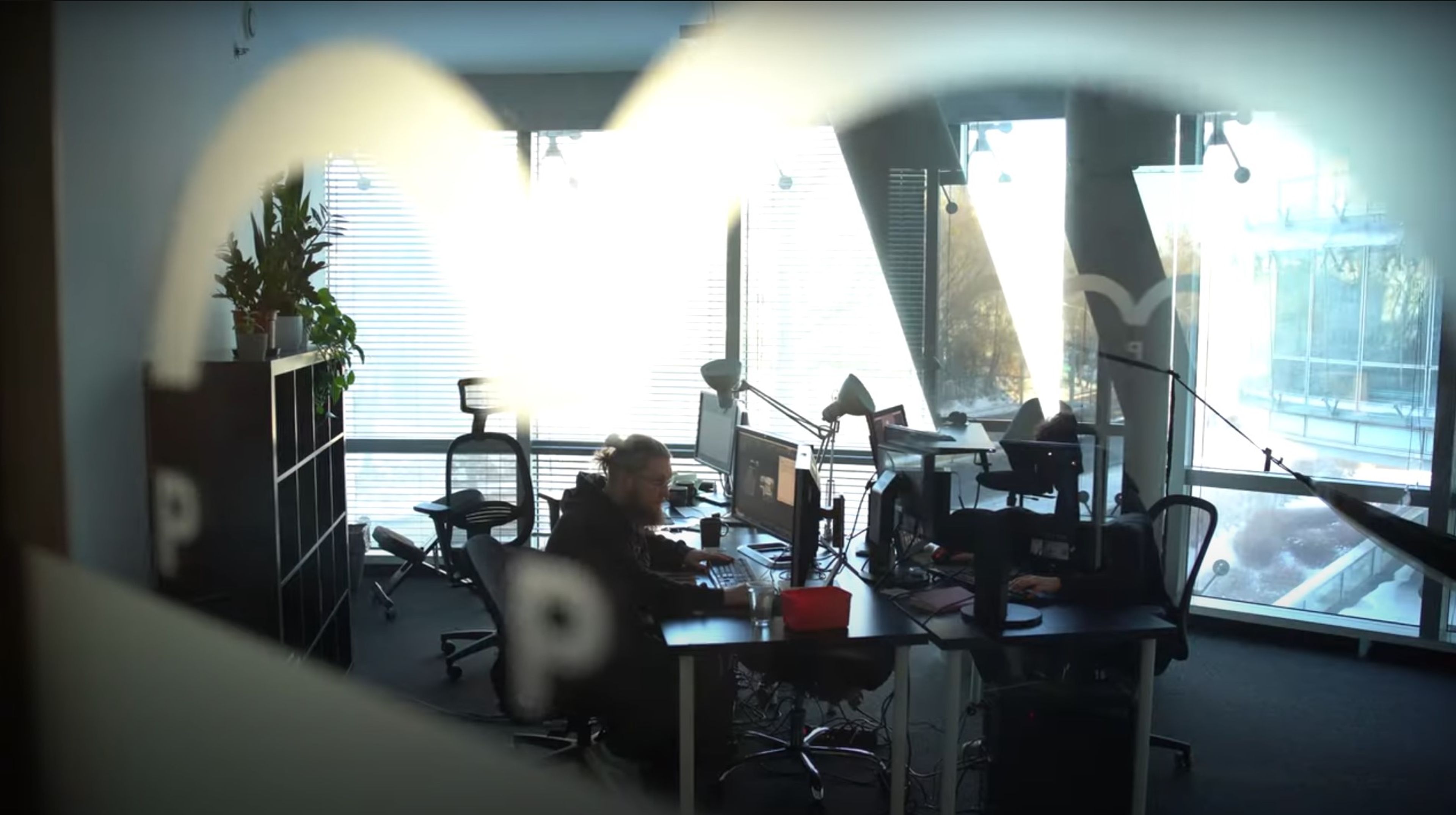 a man is sitting at a desk in an office .