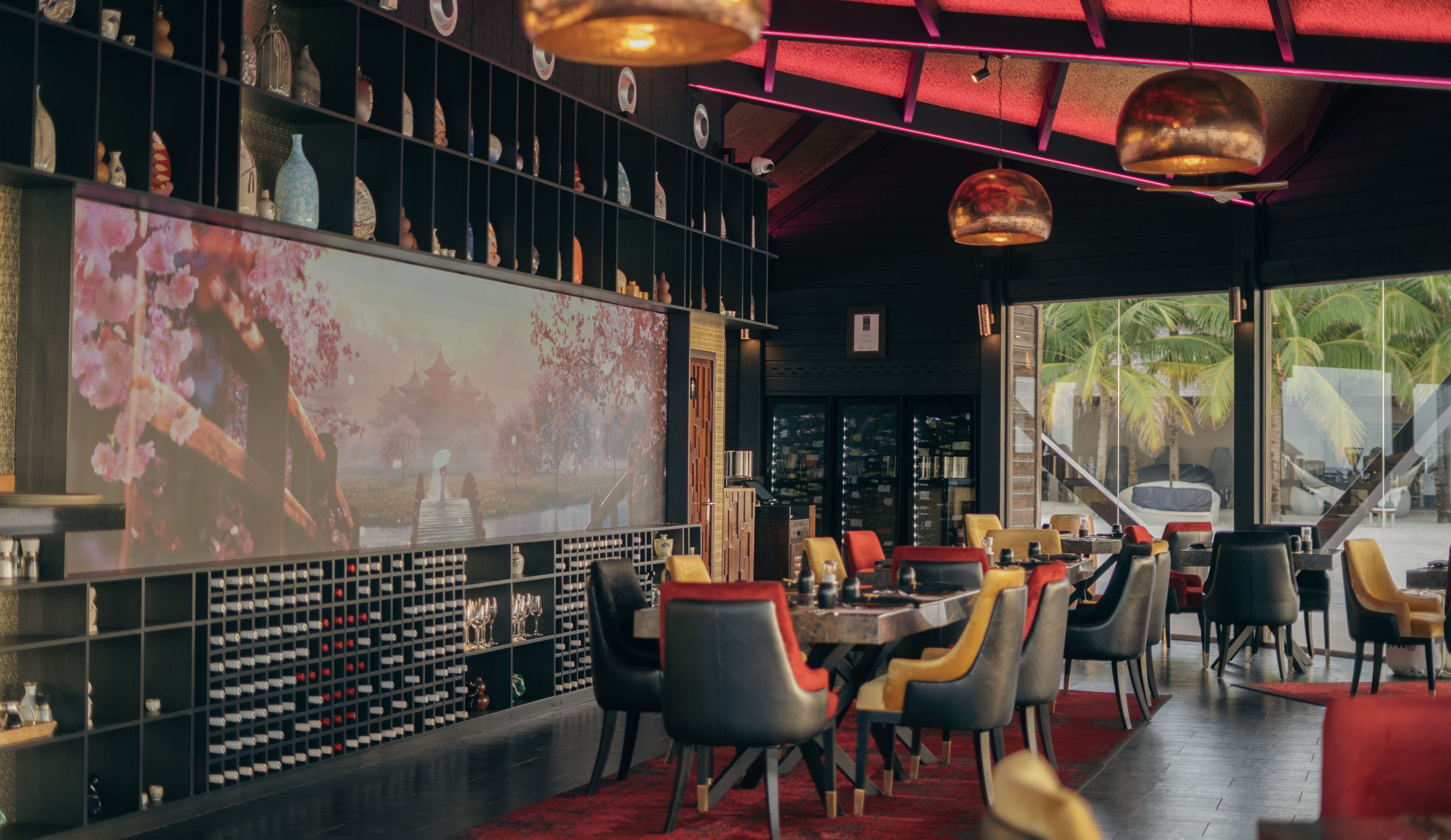 a restaurant with tables and chairs and a large screen on the wall .