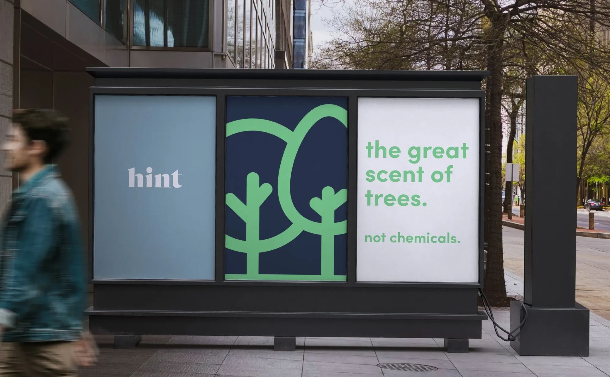 Bus stop ad mockup for Hint featuring tree graphics and the tagline “the great scent of trees. not chemicals.” promoting a natural scent alternative in a clean, minimalist layout.