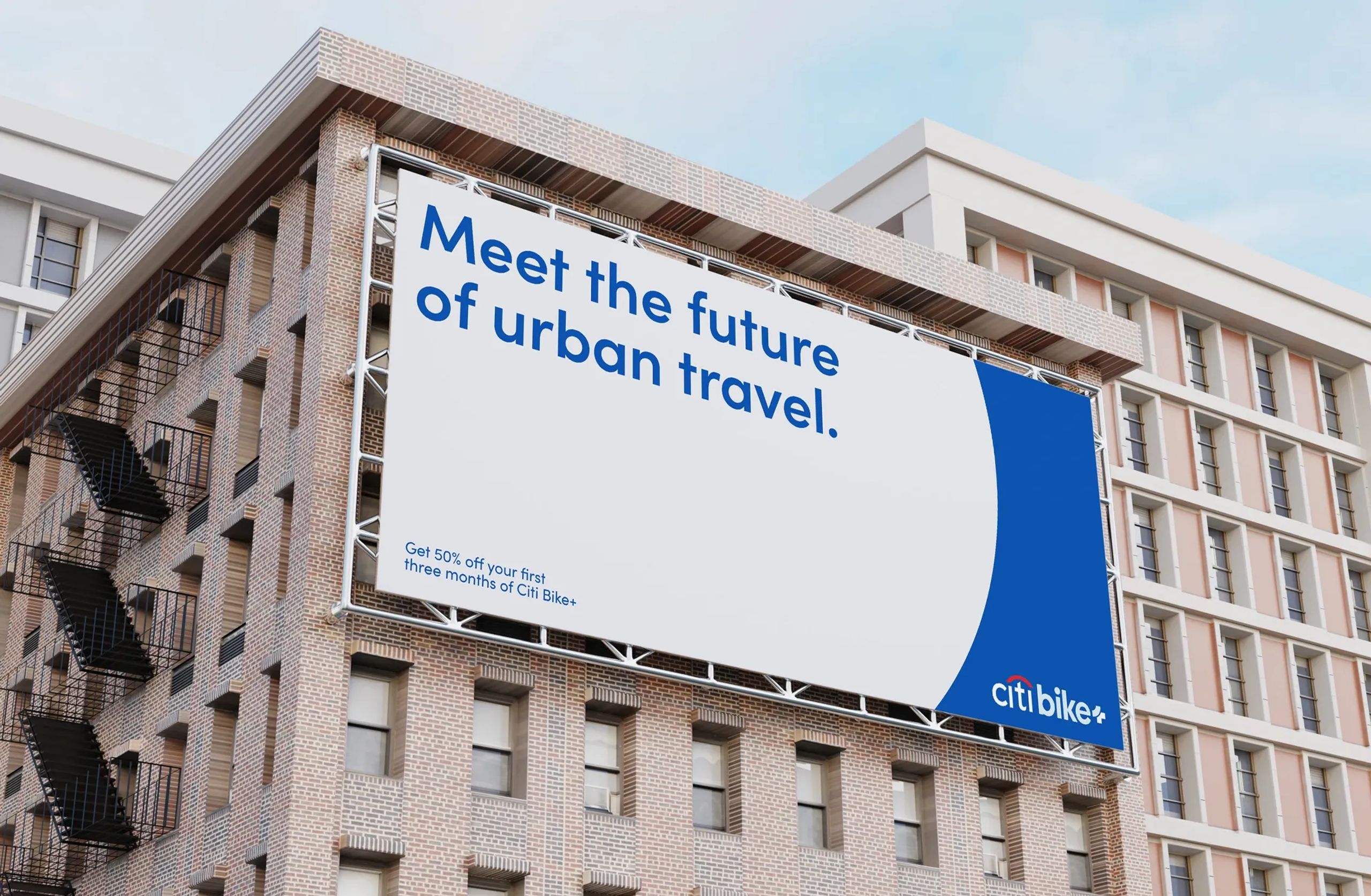 Large Citi Bike+ billboard mockup on a brick building displaying the message “Meet the future of urban travel” with a promotion offering 50% off the first three months, designed with a clean blue and white color scheme.