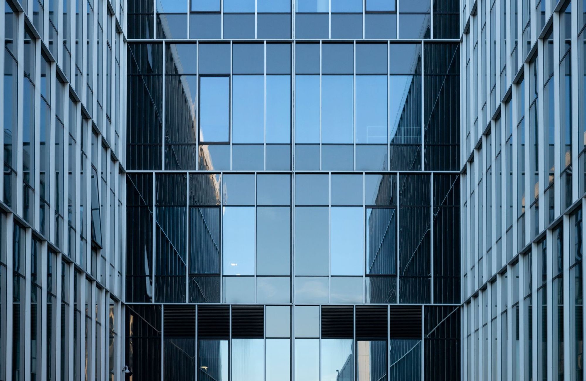 Contemporary building facade with reflective glass windows in an urban environment. (Foto: Mindaugas U / Pexels)
