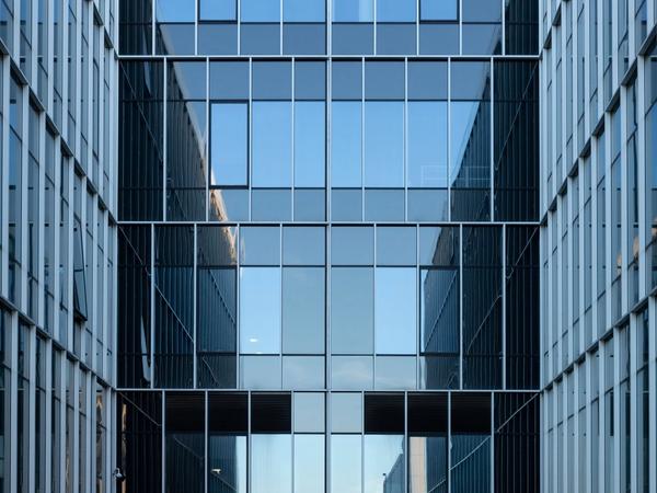 Contemporary building facade with reflective glass windows in an urban environment. (Foto: Mindaugas U / Pexels)