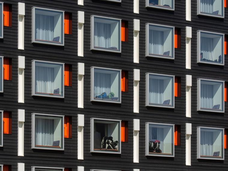 Close-up of a modern hotel facade with uniform geometric windows featuring colorful accents. (Foto: Jan van der Wolf / Pexels)