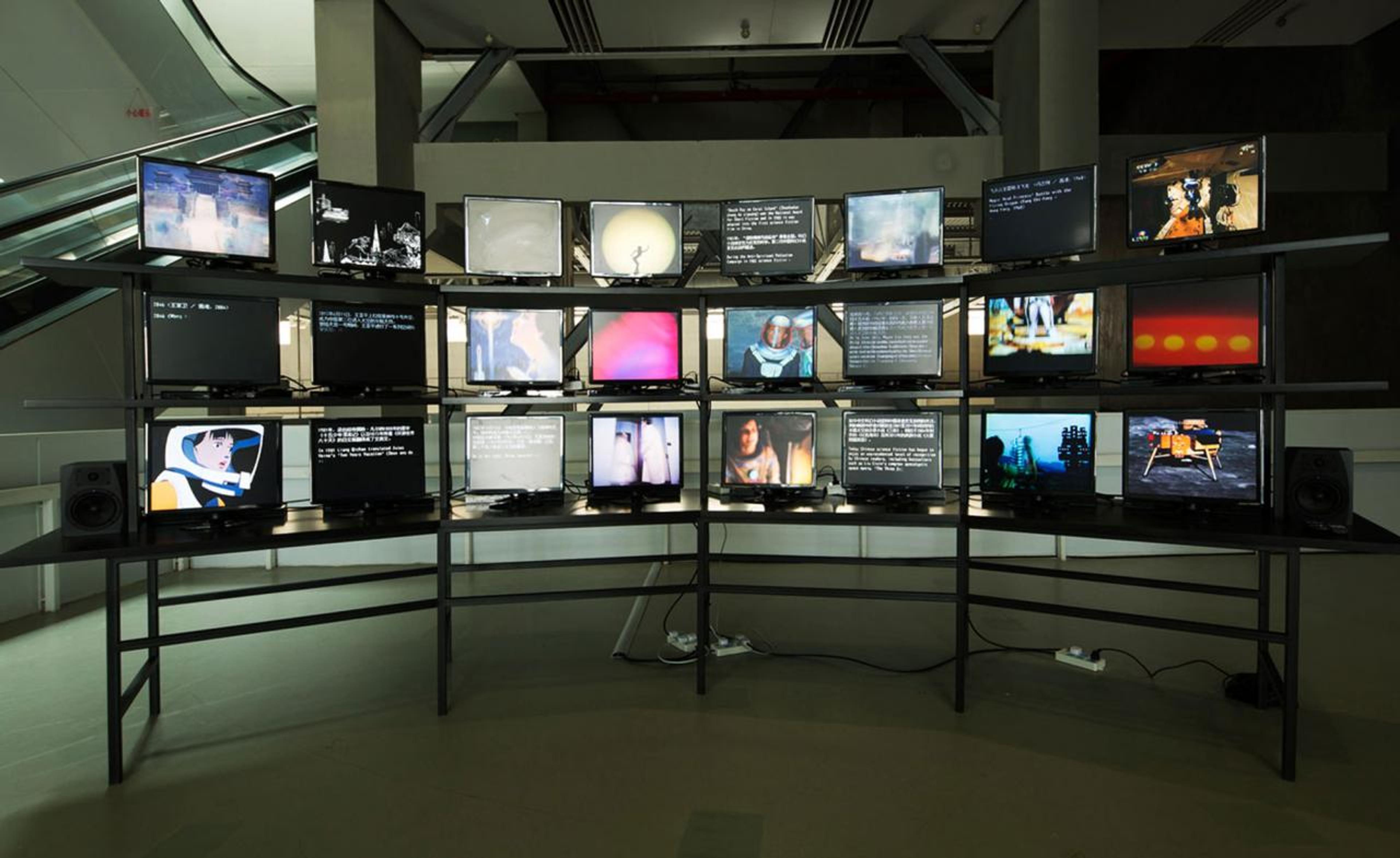 Ming Wong, Windows on the World (Part 2), 2014, twenty-four-channel standard-definition video (color, sound; varying durations), twenty-four flat screen monitors, MDF, wood, and steel, 165 × 400 × 75 cm