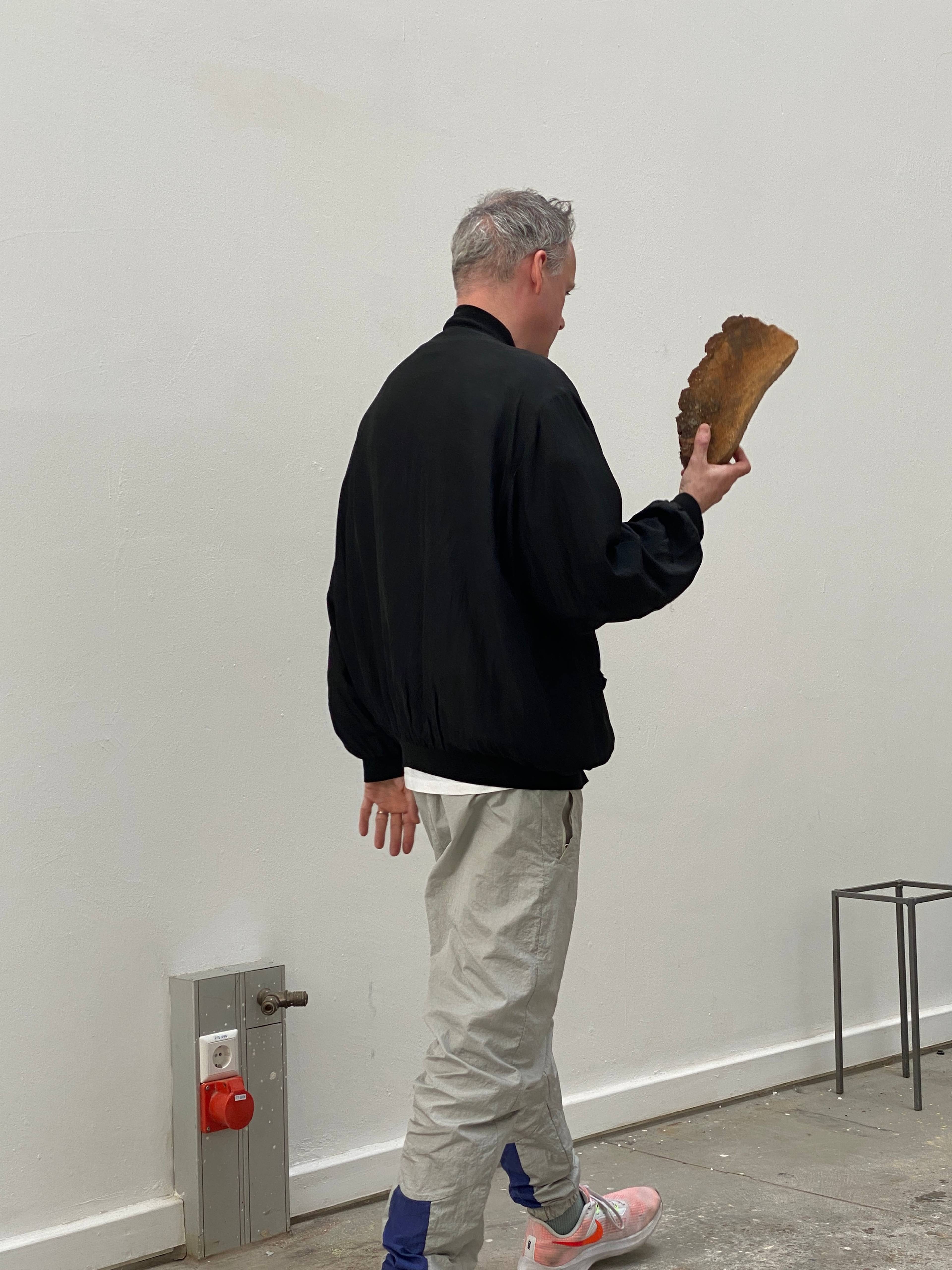 Andrew Cannon speaking during his lecture titled Welcome to the Jungle, with presentation visuals in the background, Kunstakademie Karlsruhe, 2024