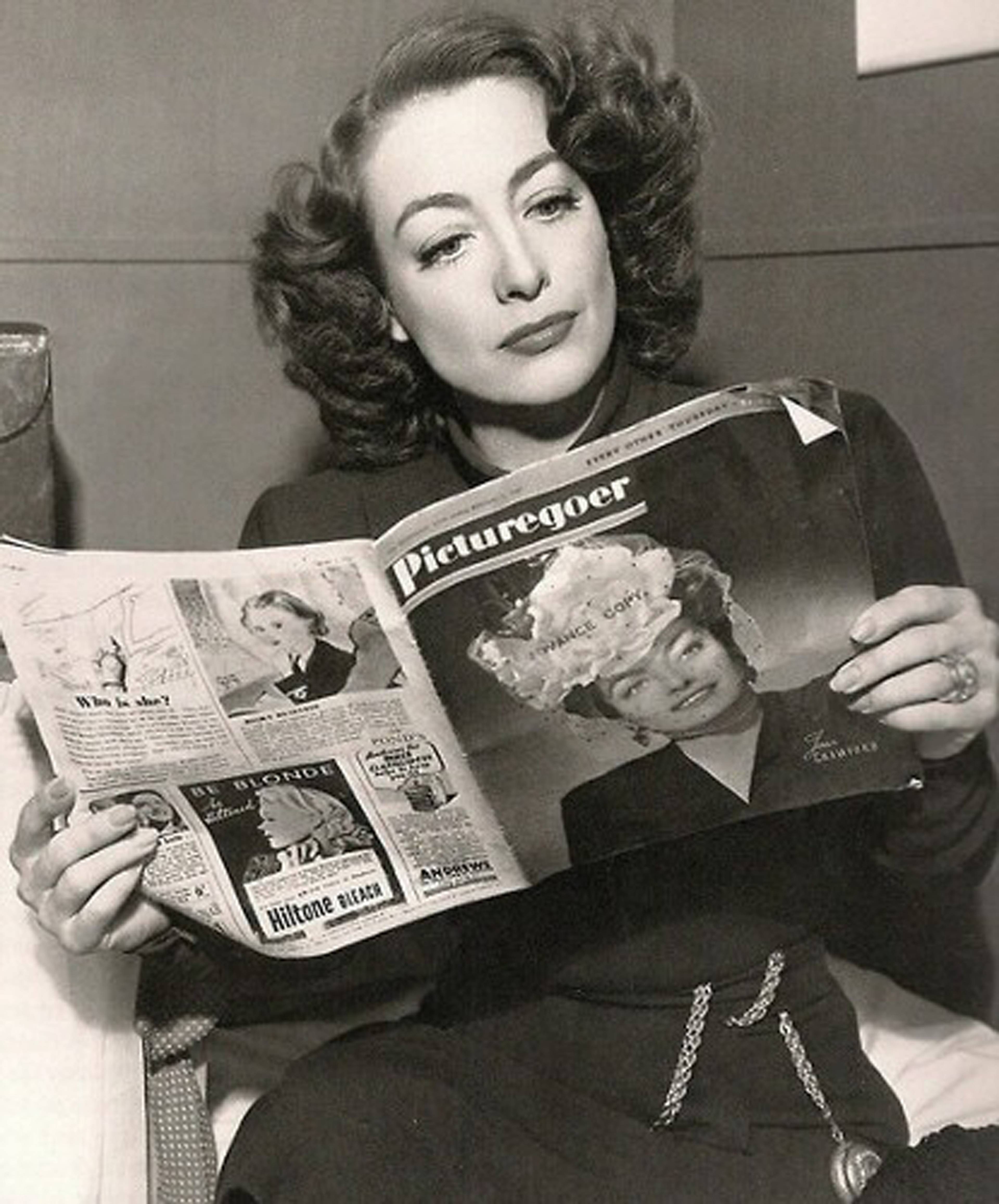 Joan Crawford looks at the 6 February 1946 issue of Picturegoer, featuring her own cover portrait
