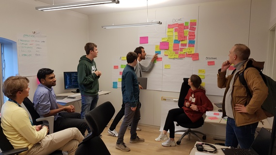 studentene henger post-itlapper på en tavle