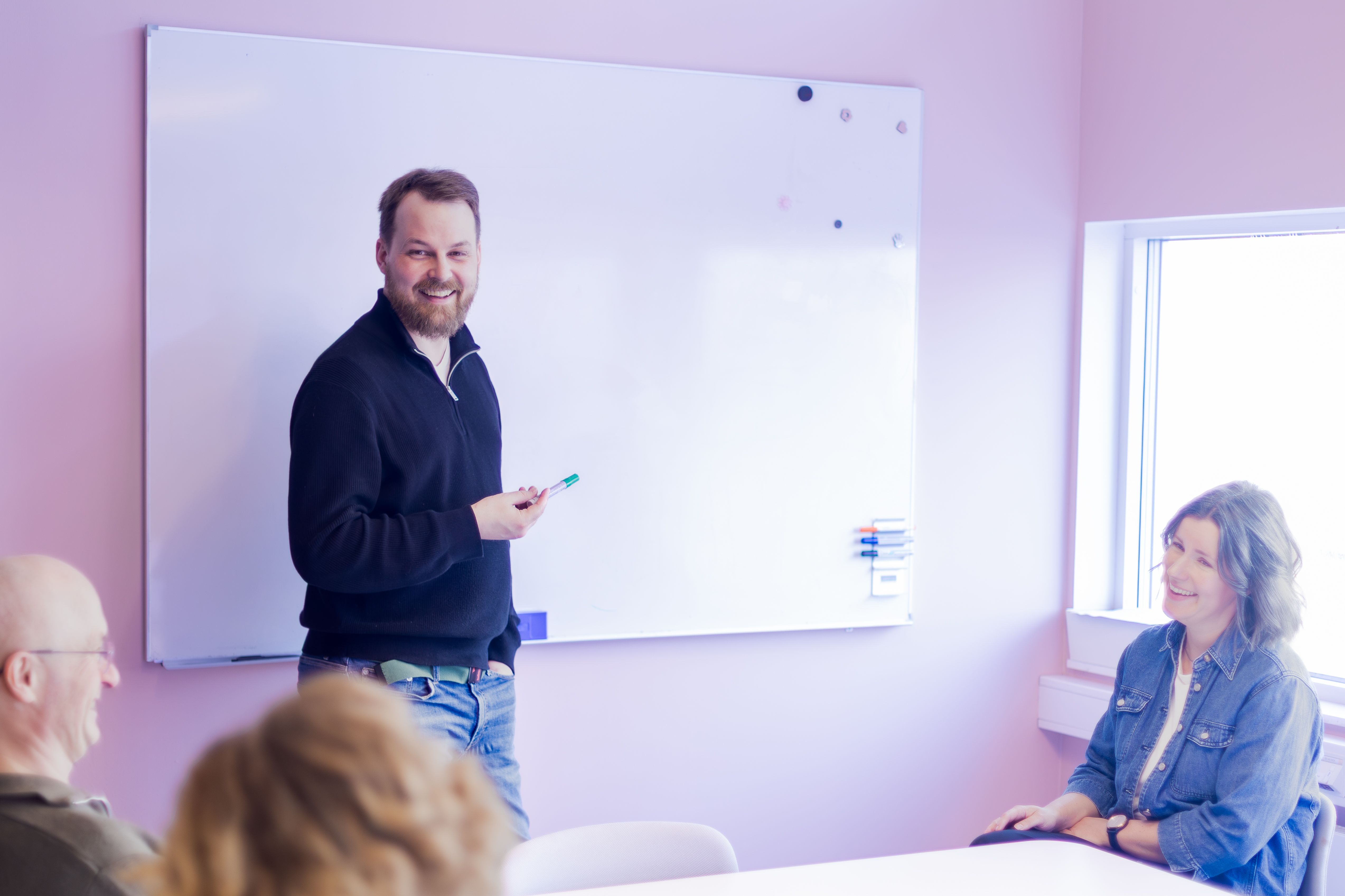 En kollega står ved en tavle og holder kurs for en gruppe.