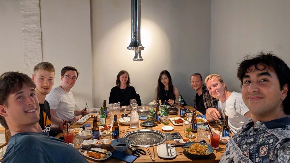 Studenter og veiledere samlet rundt et bord for å spise middag