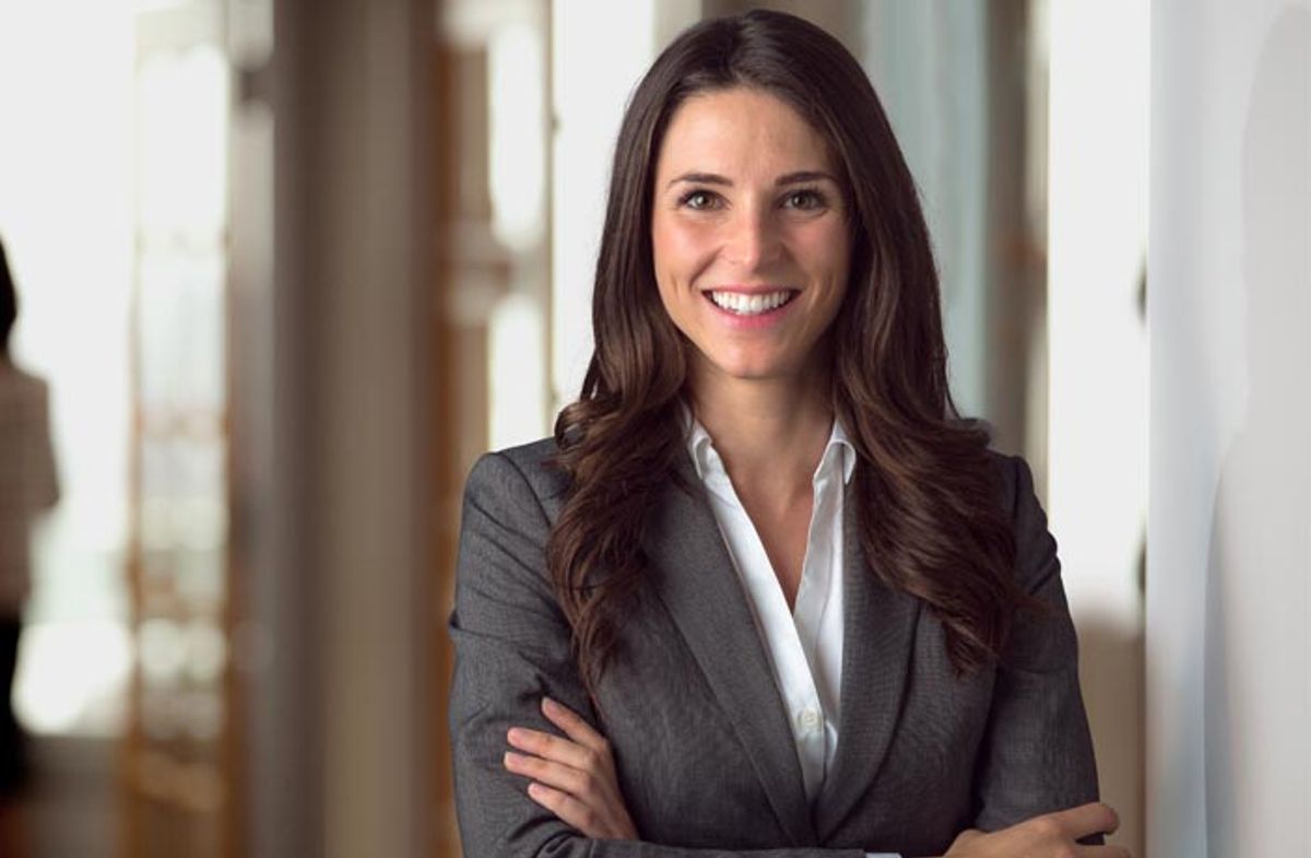 En smilende kvinne i dress.