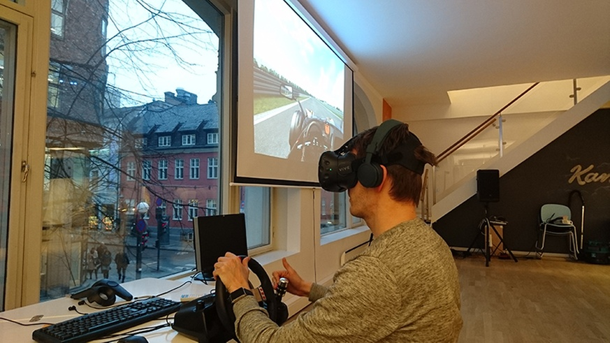 En person som kjører et billøp ved hjelp av VR briller.