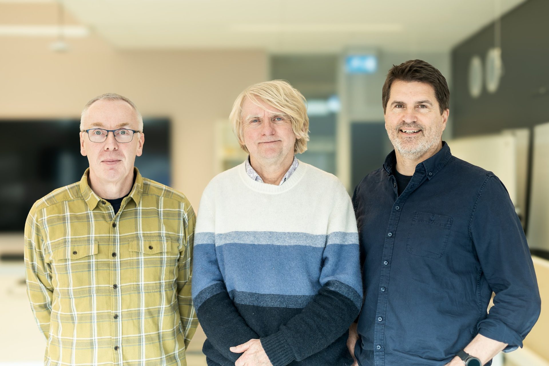 Øystein Stranden, Arnulf Hagen og Arne Faanes står ved siden av hverandre i et lyst kontorlokale.