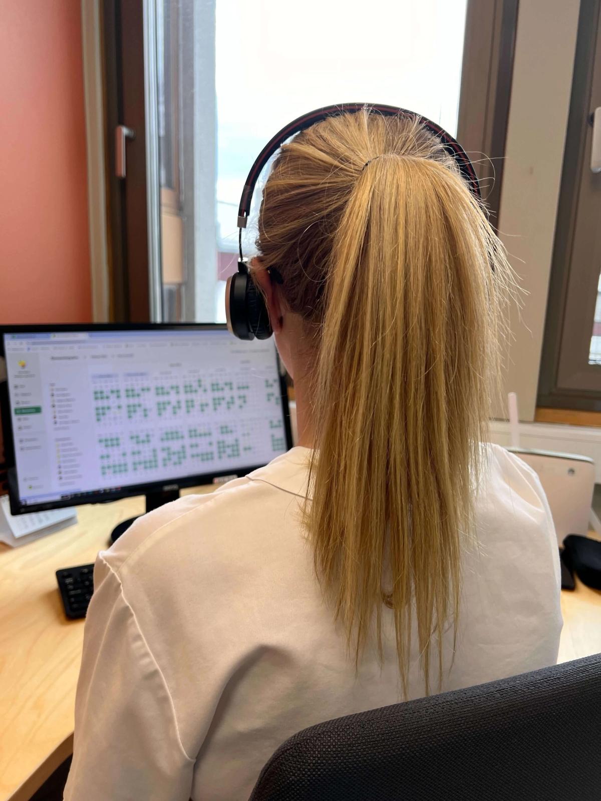 Helsearbeider sitter ved en pc og jobber med administrative oppgaver