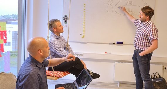 Gründerne diskuterer løsningen ved en tavle.