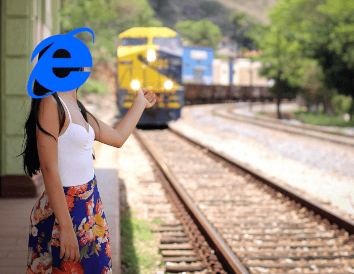 En dame med Internet Explorer-ikonet i ansiktet, gir signal til et tog at det skal stoppe for henne.