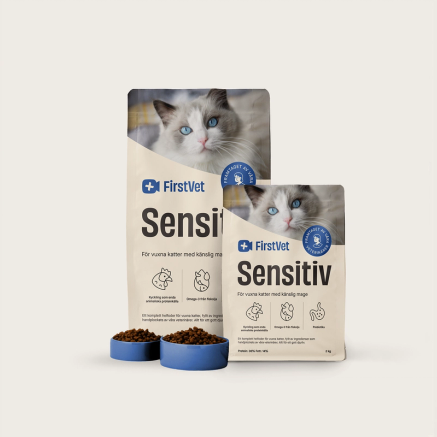 Påsar med kattmat från FirstVet Sensitiv. Med blåa, fyllda matskålar framför.