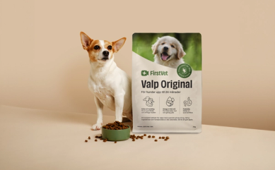 Hunden Doris poserar bredvid en påse FirstVet Valp